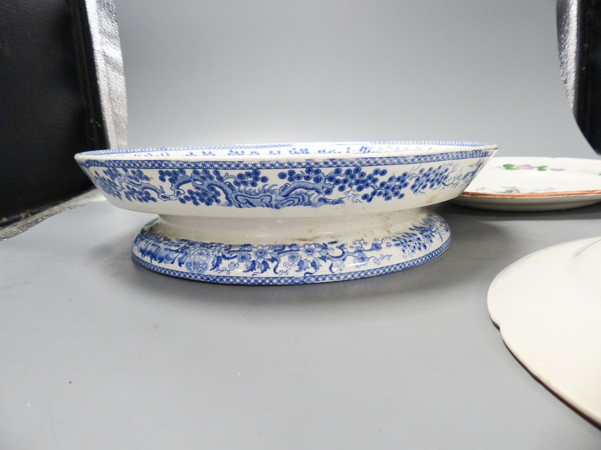 An ironstone cheese stand and a pair of French faience plates 30cm